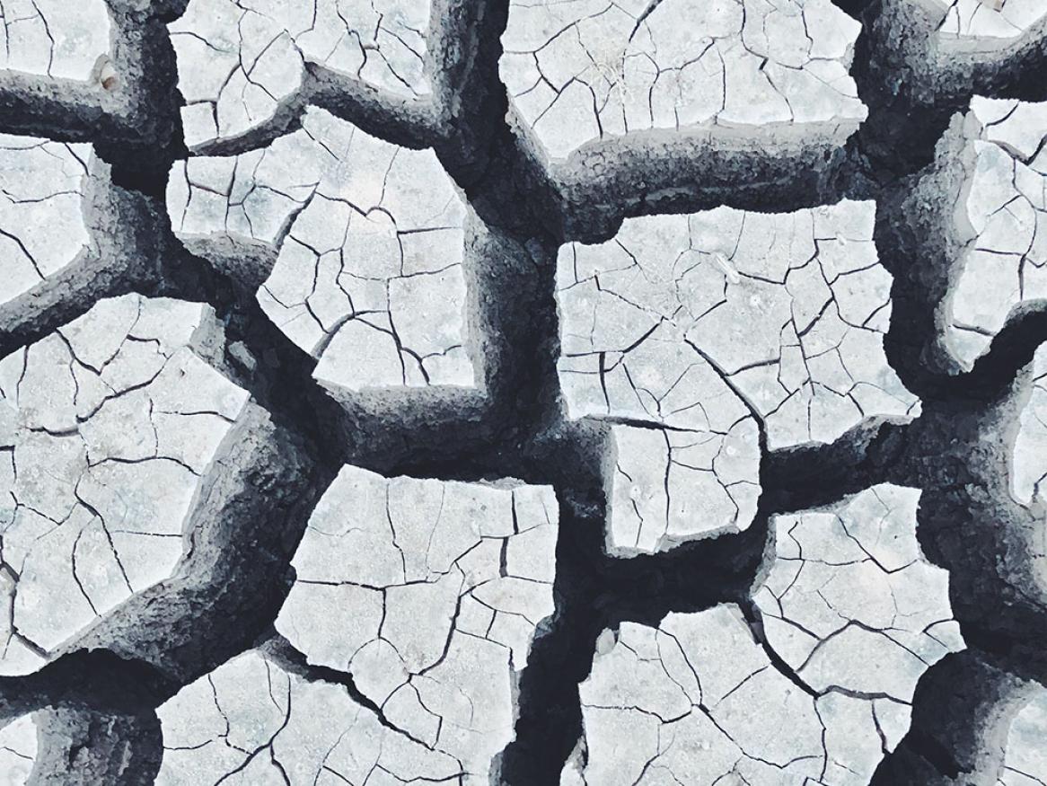 A stylized image of dried and cracked soil representing fragmentation